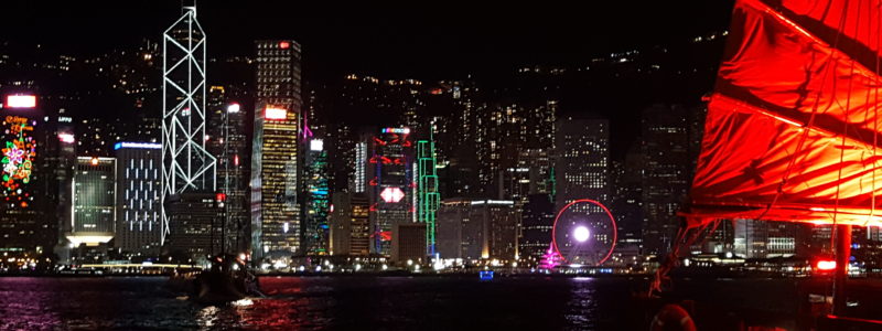 Hong Kong skyline at night with a Sampan in Victoria Harbour